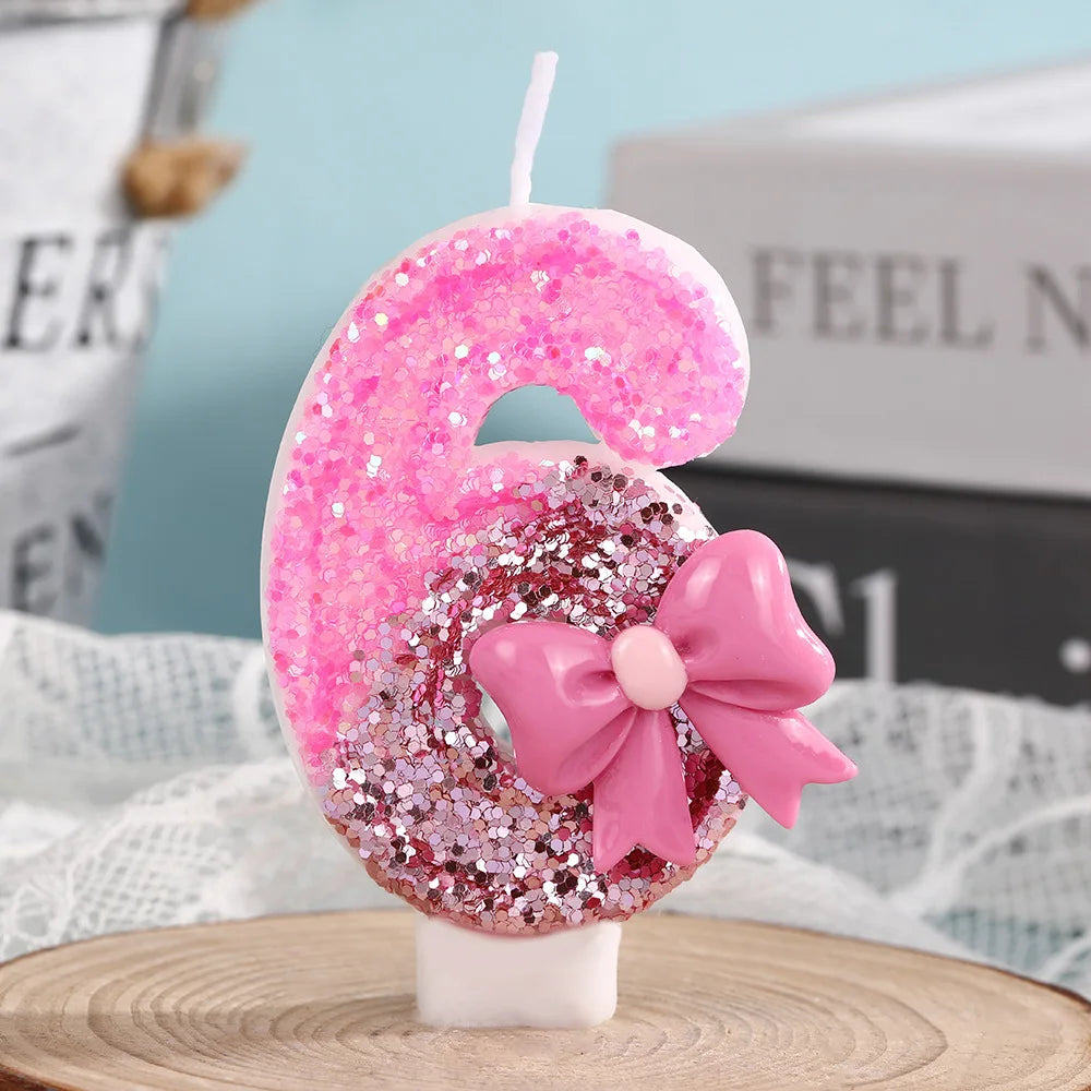 Pink glitter number six candle with a pink bow on a white stick