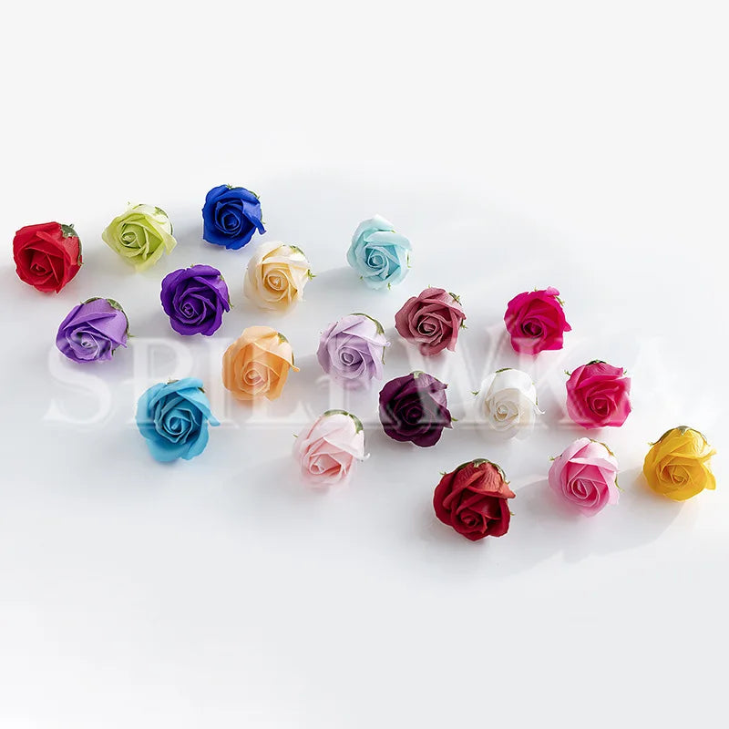 A collection of artificial rose heads in various shades of red, pink, purple, blue, and yellow arranged on a white background