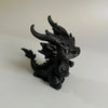 Figurine de dragon miniature noir pour bureau avec des cornes pointues et des traits faciaux féroces.