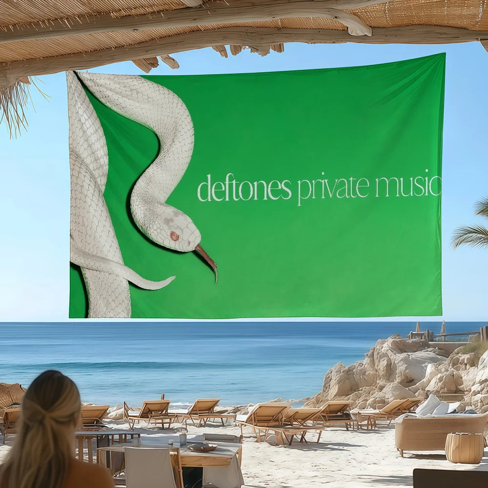 A large green flag featuring a white bird silhouette and the text deftones private music displayed outdoors.