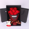 A gift box containing a red rose bouquet and a plush white bear.