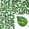 Green artificial ivy vine garland covering a white background with a single leaf detail