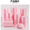 A display of pink silk satin ribbons rolled into various sizes and stacks for crafting.
