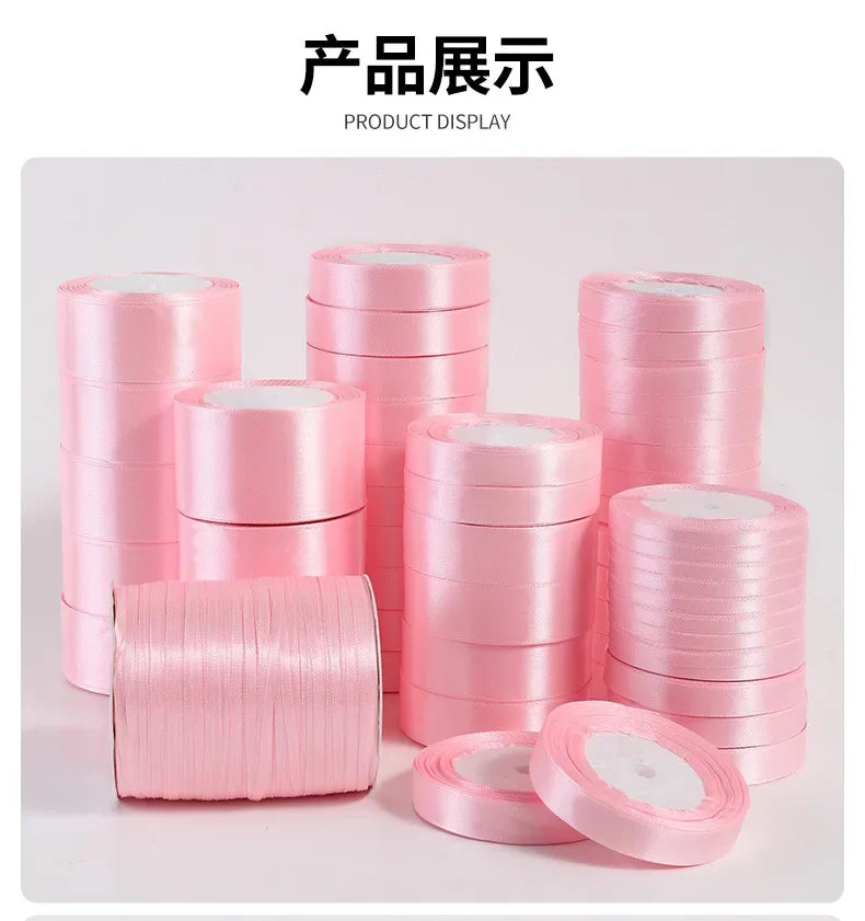 A display of pink silk satin ribbons rolled into various sizes and stacks for crafting.