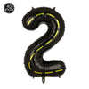 A black inflatable number 2 shaped like a construction vehicle for a birthday party.
