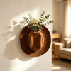A brown felt cowboy hat serves as a wall vase holding a small bouquet of yellow wildflowers.