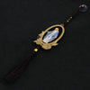 A wooden pendant ornament depicting Our Lady of Grace with a blue and white robe, suspended by a dark cord.