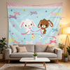 A light blue tapestry featuring whimsical stars and bows, displayed above a modern sofa.