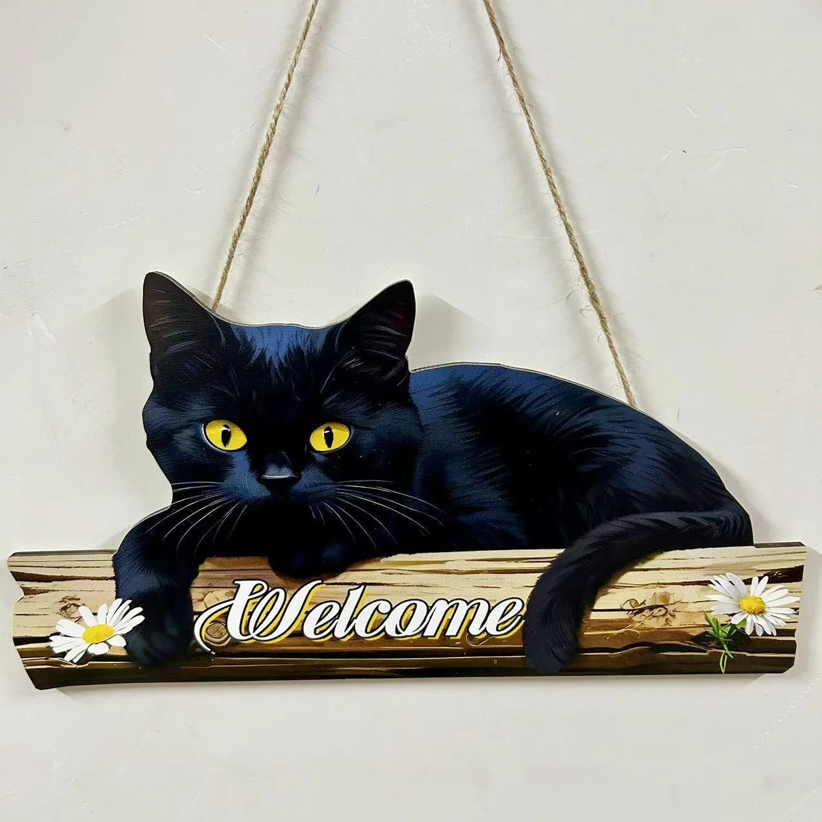 A black cat silhouette on a rustic wooden sign with the word welcome carved into it.