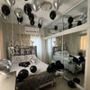 Silver alphabet and heart balloon set used as party decorations on a bed display