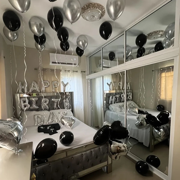Silver alphabet and heart balloon set used as party decorations on a bed display