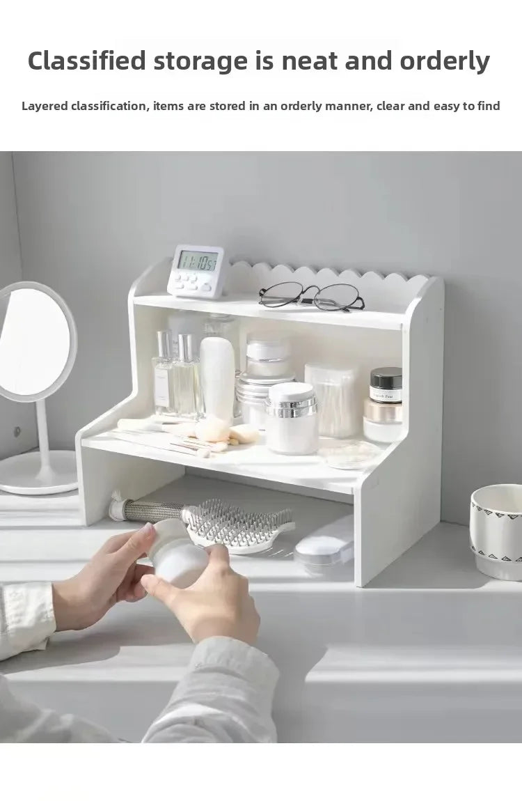 A white two-layer desktop organizer shelf displaying neatly stored items like glasses and skincare products.
