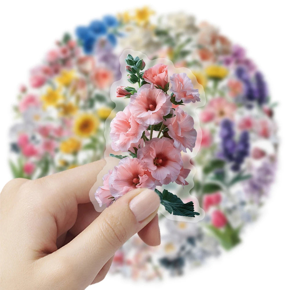 A hand holds a clear flower decal featuring pink and green flowers against a colorful floral background.