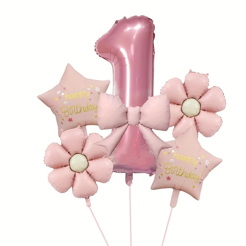 A cluster of pink foil balloons shaped like the number one and flowers for a birthday celebration