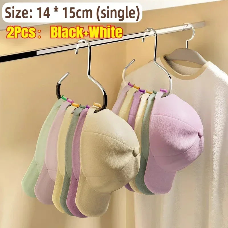 Two black and white round multi-purpose closet hooks hanging on a metal rod