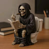 A dark resin statue of a skull wearing a hood holding a pipe and a newspaper, sitting on a toilet.