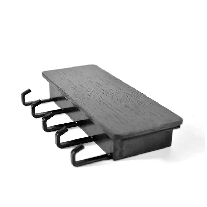A dark wood bamboo wall-mounted key rack with six hooks.