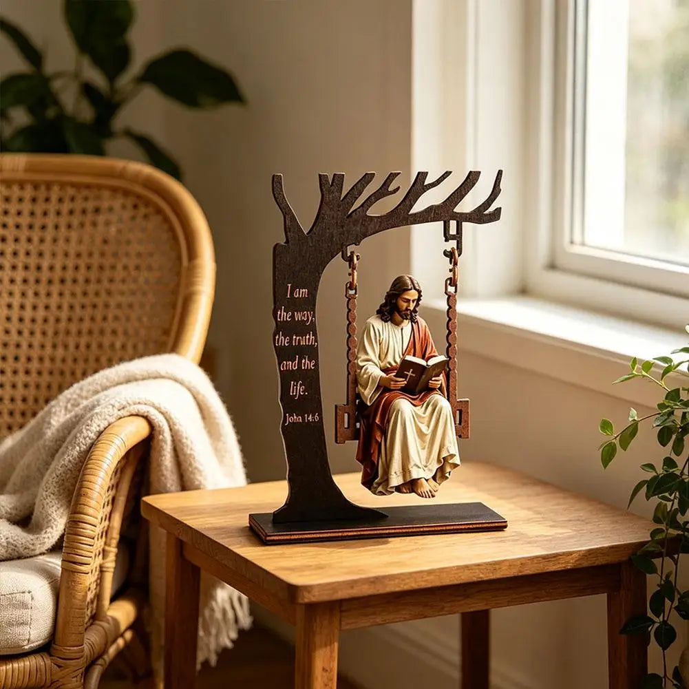 Wooden silhouette of Jesus swinging on a branch with the Bible verse John 14:6 on a wooden table.