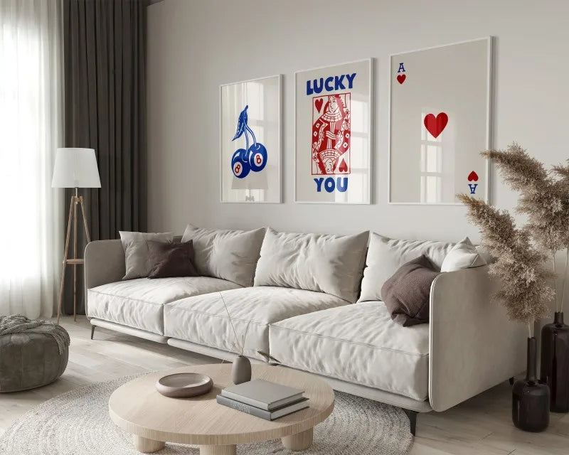 A modern living room features a light sofa and decorative wall art with red and blue designs.