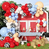 A red barn decorated with a balloon garland featuring various colored balloons and black and white polka dot balloons.