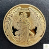A gold souvenir coin featuring the figure of Saint Michael with wings and a spear.