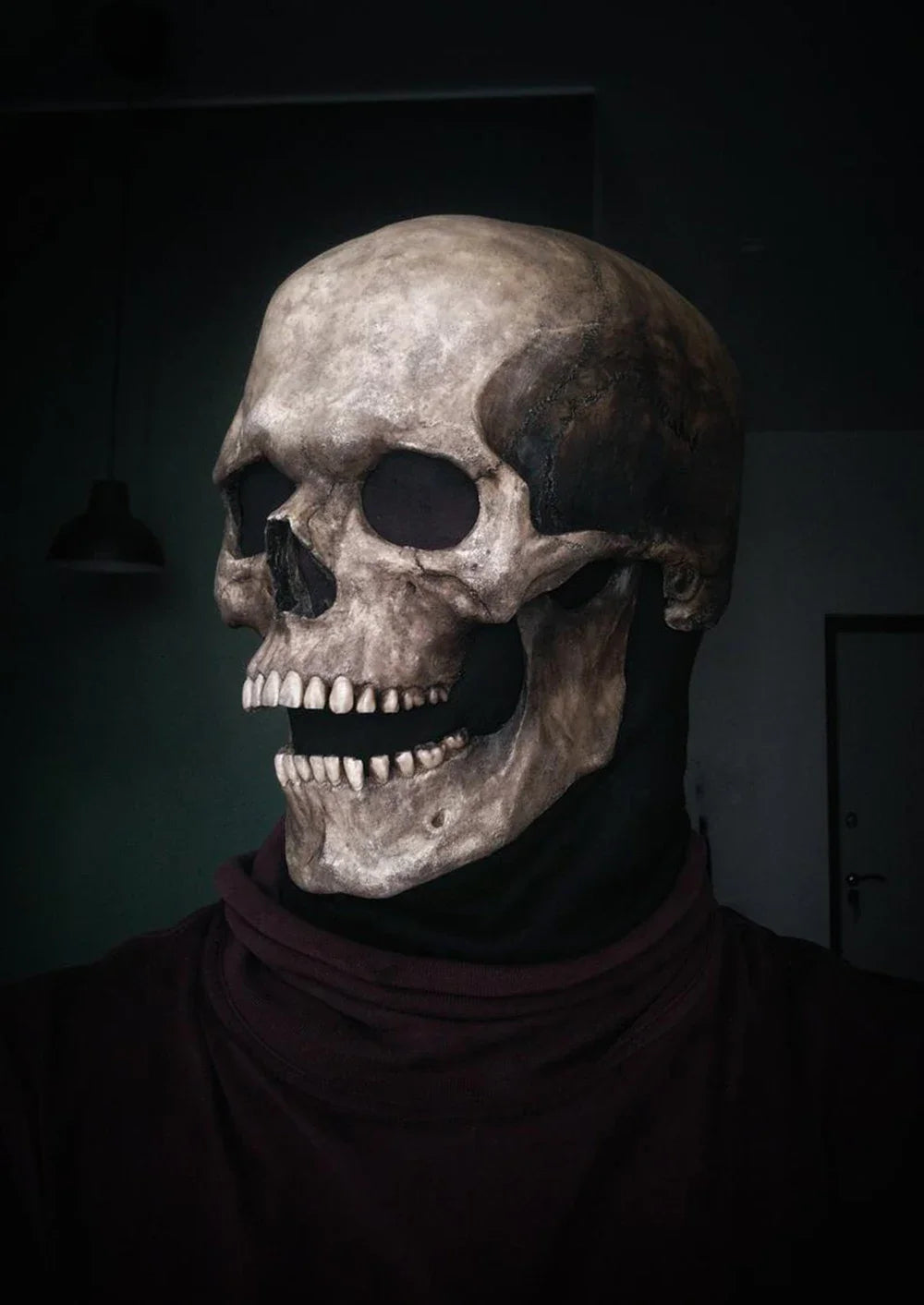 A realistic latex skull cosplay mask displayed against a dark background.