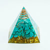 A pyramid-shaped crystal display featuring turquoise stones and gold flakes.