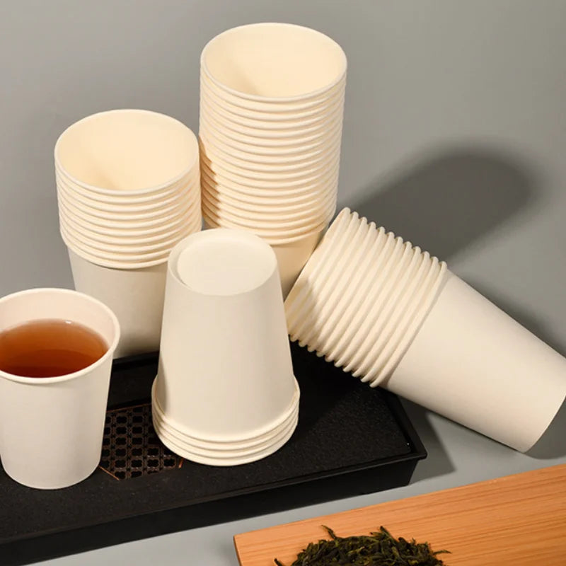 A stack of disposable paper cups in off-white and beige colors are displayed on a black tray.