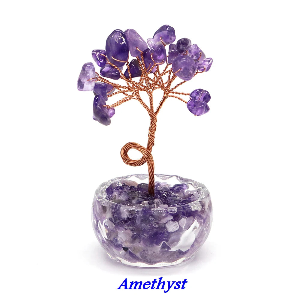 A crystal healing gemstone bonsai featuring purple amethyst crystals on a wooden branch set in a clear stone base.