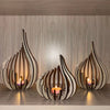Handcrafted wooden lotus candle holders with tapered petals and flame light on a wooden surface.