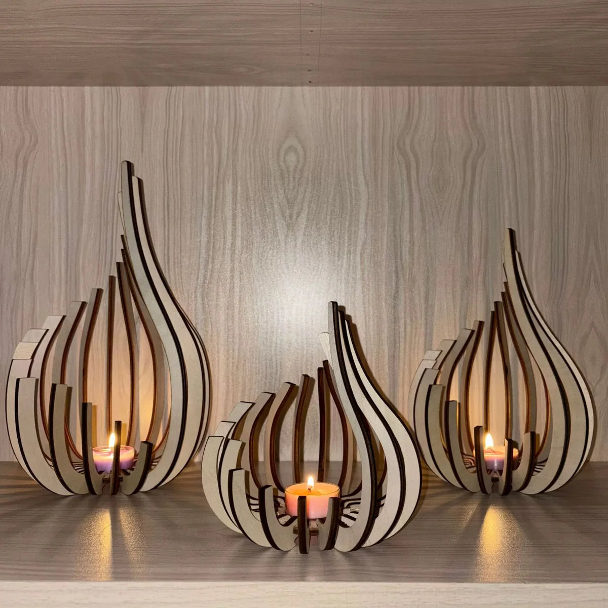 Handcrafted wooden lotus candle holders with tapered petals and flame light on a wooden surface.