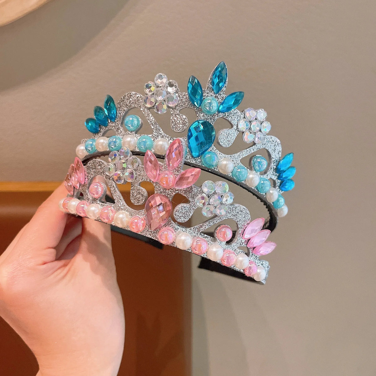 A set of three sparkling pearl headbands featuring pink and blue floral accents.