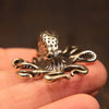 Antique brass octopus desk ornament resting on a person's hand.