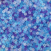 A close-up view of small, round frosted glass rice beads in shades of blue and purple.