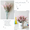 A bouquet of pink and green lavender artificial flowers in a white pot for home decor.