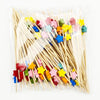 A collection of pearl-tipped bamboo cocktail picks in various colors and shapes.