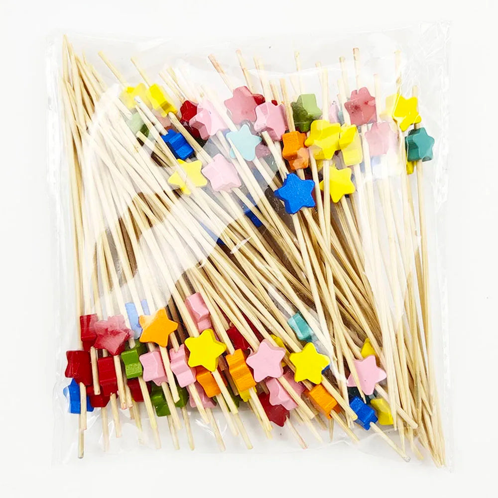 A collection of pearl-tipped bamboo cocktail picks in various colors and shapes.