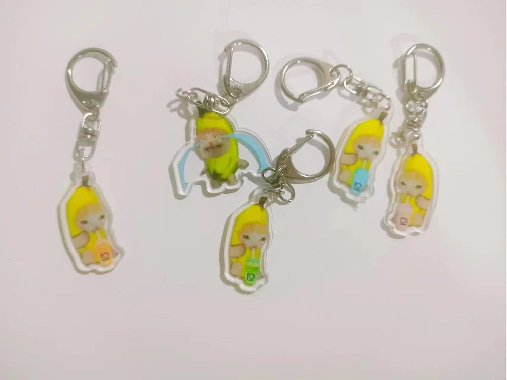 Acrylic keychain featuring a yellow cat with a banana and blue accents.