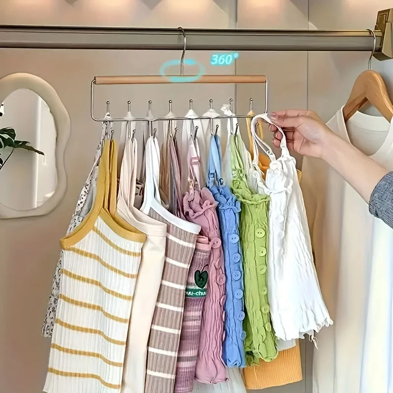 A display of various colored knitted sweaters and shirts hanging on a wall-mounted metal coat rack.
