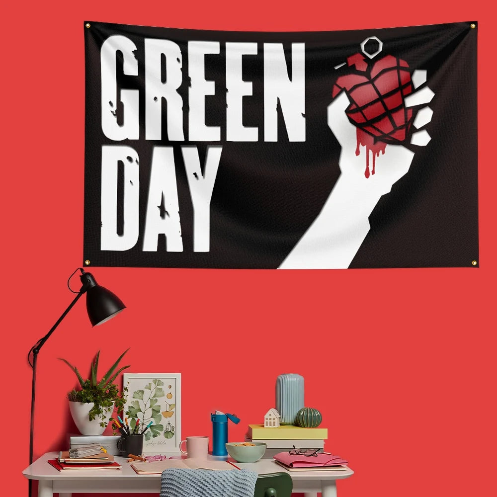 A black banner featuring the text GREEN DAY and a hand holding a heart design with red paint on a red wall.