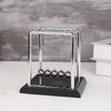 A chrome Newton's cradle display with glass balls on a black base.
