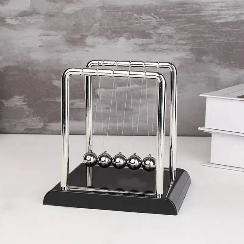 A chrome Newton's cradle display with glass balls on a black base.