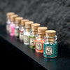 A row of small glass bottles filled with colorful glitter powder for party decorations