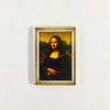 A framed painting of a woman in dark clothing against a golden background, used as decor.