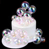 A display of iridescent, spherical balloon cake toppers in various shades of pink and purple.