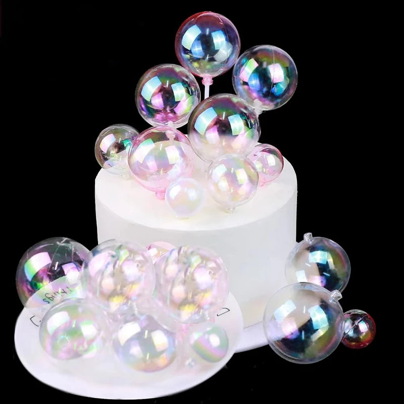 A display of iridescent, spherical balloon cake toppers in various shades of pink and purple.