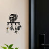 A black iron skull wall hook with a floral accent displaying various hooks and accessories.