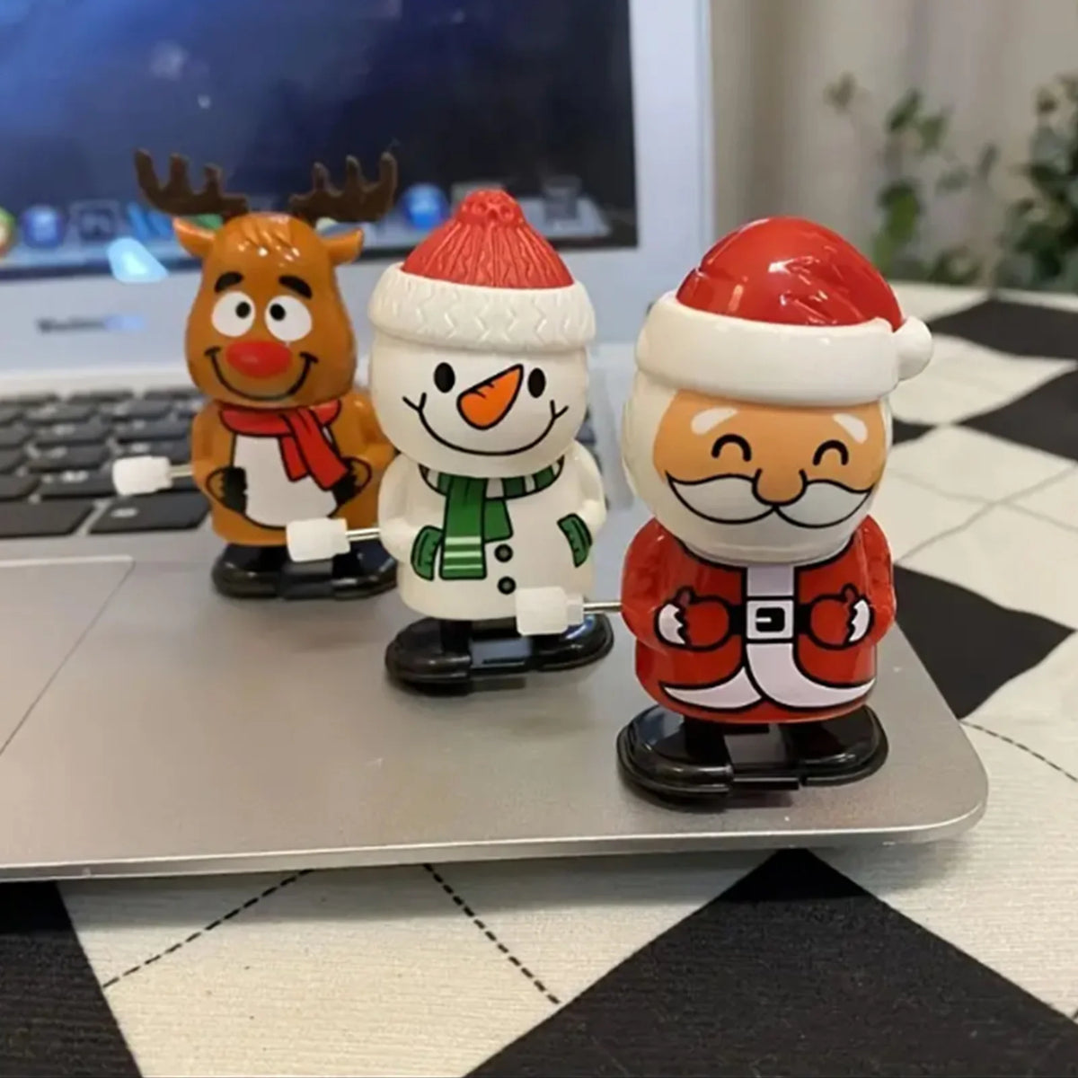 Three clockwork wind-up figurines depicting a reindeer, a snowman, and Santa Claus for festive decor