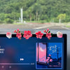 A close-up view of a car dashboard featuring a 3D peach blossom ornament with pink and red flowers.