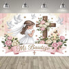 A pink and white First Communion backdrop featuring a girl, doves, roses, and a wooden cross design.